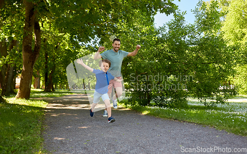 Image of happy father and son compete in running at park