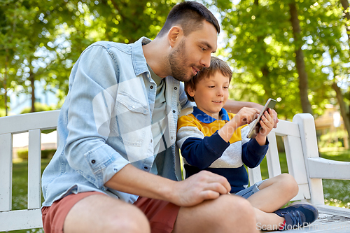 Image of father and son with smartphone at park