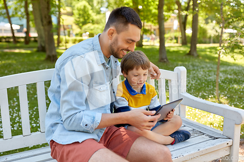 Image of father and son with tablet pc computer at park