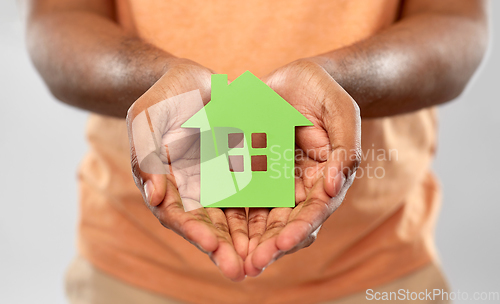 Image of close up of african man holding green house