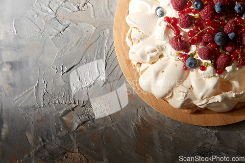 Image of pavlova meringue cake with berries on wooden board