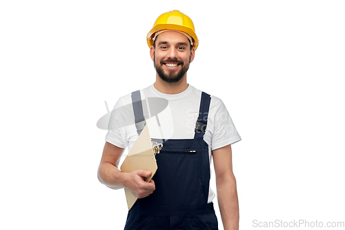 Image of happy worker or builder in helmet with clipboard