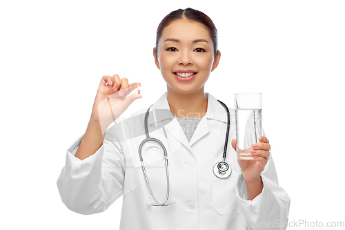 Image of asian doctor with medicine and glass of water
