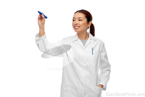 Image of happy asian female doctor writing with blue marker