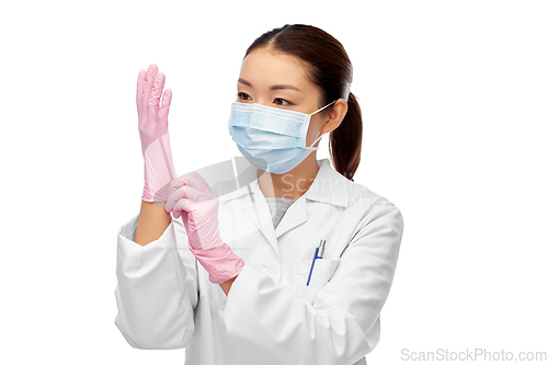 Image of asian female doctor in medical mask and gloves