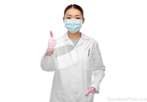 Image of asian female doctor in mask showing thumbs up