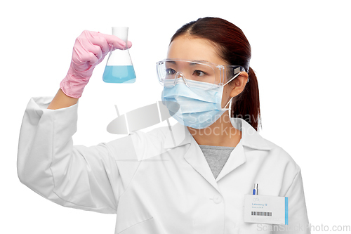 Image of asian female scientist in mask with chemical