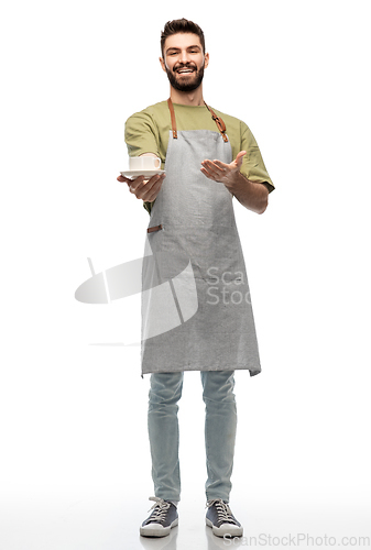 Image of happy smiling waiter in apron with cup of coffee