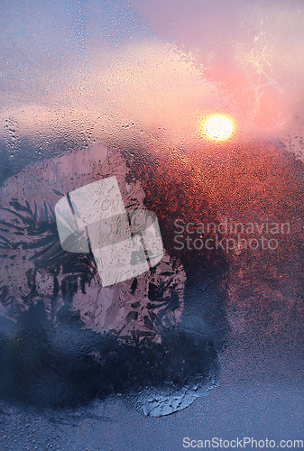 Image of Ice pattern and water drops on glass on a sunny winter morning