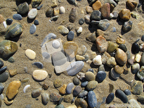 Image of Wet sea pebbles on the sand