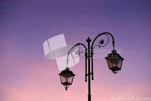 Image of Beautiful vintage street lamp against a bright sunrise sky