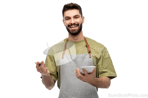 Image of smiling waiter in apron taking notes to notepad