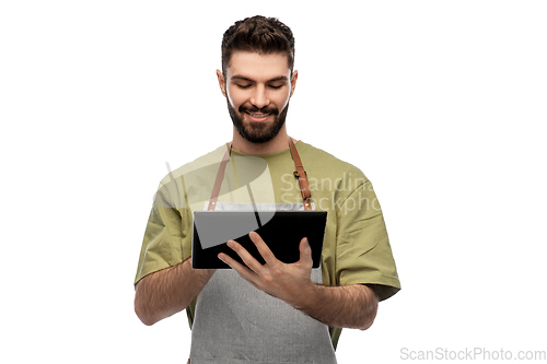 Image of smiling waiter in apron with tablet pc computer