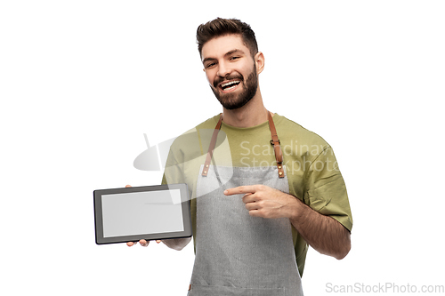 Image of smiling waiter in apron showing tablet pc computer