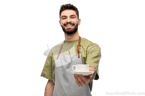 Image of happy smiling waiter in apron with cup of coffee