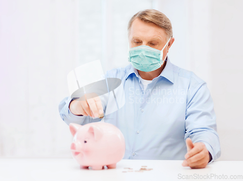 Image of old man in mask putting coin into big piggy bank