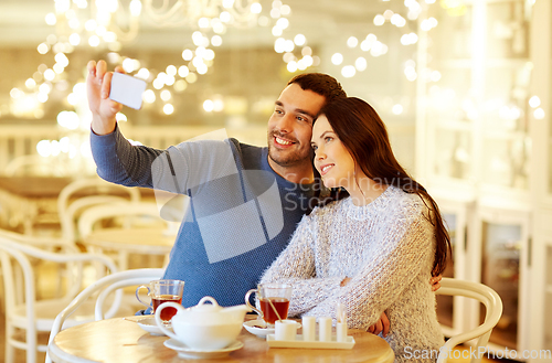 Image of couple taking smartphone selfie at cafe restaurant