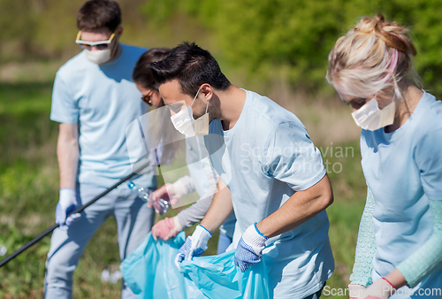 Image of volunteers in masks with cleaning garbage at park