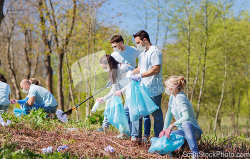 Image of volunteers in masks with cleaning garbage at park