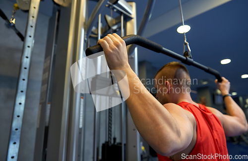 Image of close up of man exercising on cable machine in gym