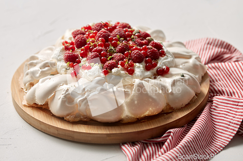 Image of pavlova meringue cake with berries on wooden board