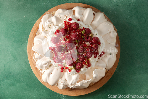 Image of pavlova meringue cake with berries on wooden board