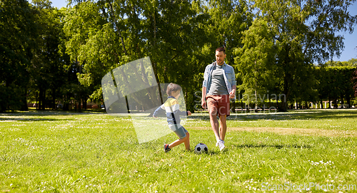 Image of father with little son playing soccer at park