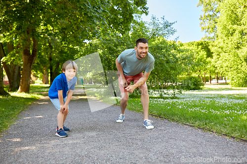 Image of happy father and son compete in running at park