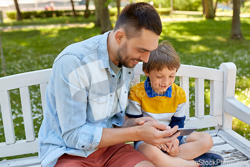 Image of father and son with smartphone at park