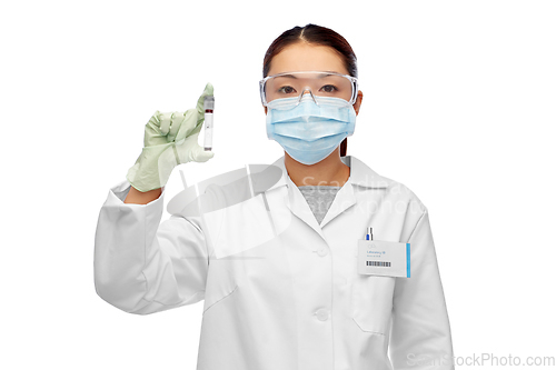 Image of asian female doctor holding beaker with blood test