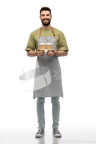 Image of happy smiling barman in apron with takeaway coffee