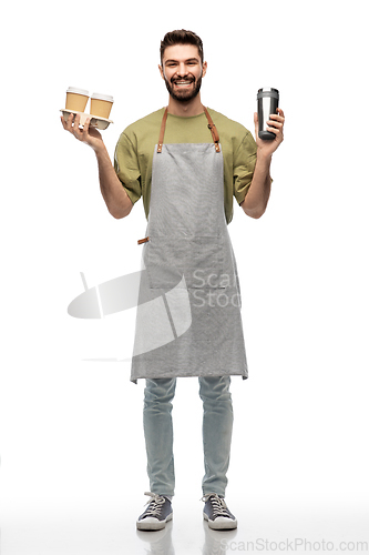 Image of happy waiter with takeout coffee cups and tumbler