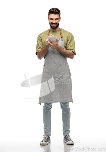 Image of smiling waiter in apron taking notes to notepad