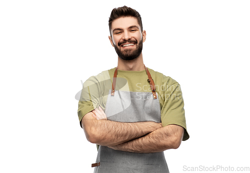 Image of happy smiling barman in apron with crossed arms
