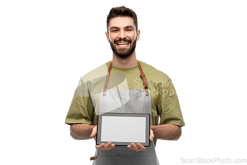 Image of smiling waiter in apron showing tablet pc computer