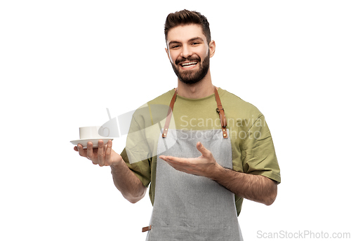 Image of happy smiling waiter in apron with cup of coffee