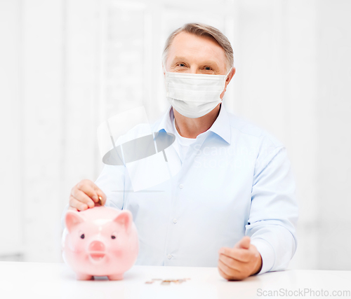 Image of old man in mask putting coin into big piggy bank