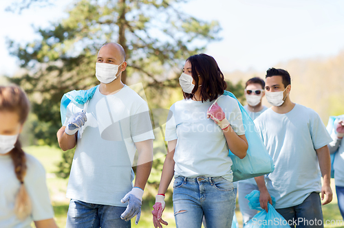 Image of volunteers in masks with garbage bags in park