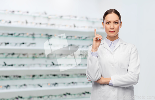 Image of female doctor pointing finger up at optical store