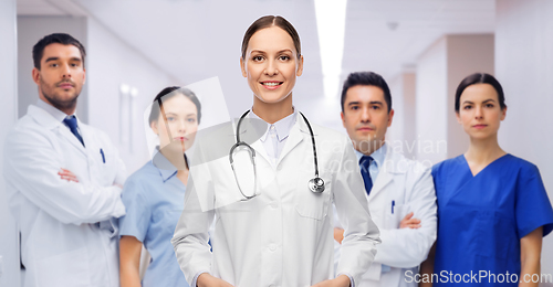 Image of smiling female doctor with colleagues at hospital