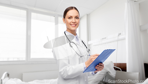 Image of smiling female doctor with clipboard at hospital