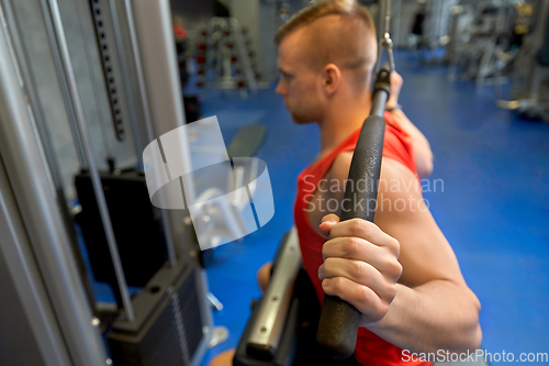 Image of close up of man exercising on cable machine in gym