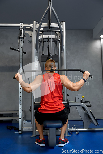 Image of close up of man exercising on cable machine in gym