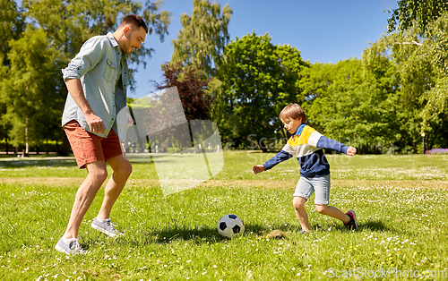 Image of father with little son playing soccer at park