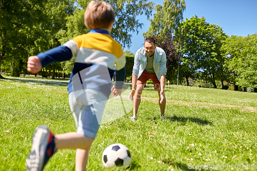 Image of father with little son playing soccer at park