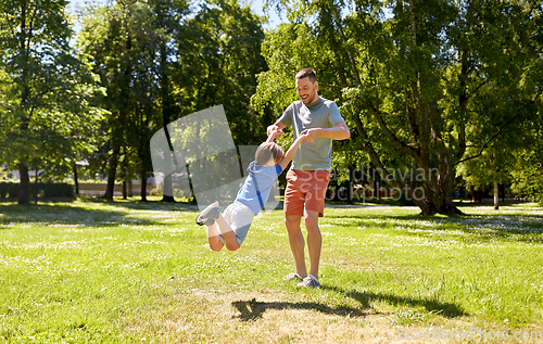 Image of happy father with son playing in summer park