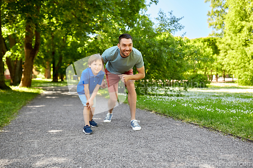 Image of happy father and son compete in running at park