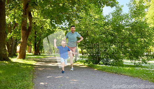 Image of happy father and son compete in running at park
