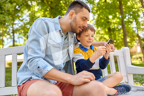 Image of father and son with smartphone at park