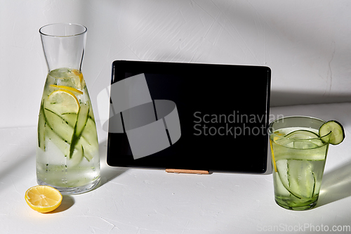 Image of water with lemon and cucumber and tablet computer